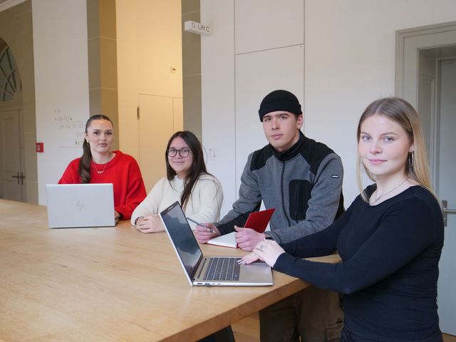 Différents apprenants réunis autour d'une table.