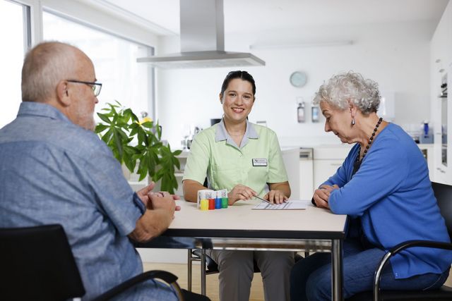 Mitarbeiterin in der Pflege, mit 2 älteren Personen.