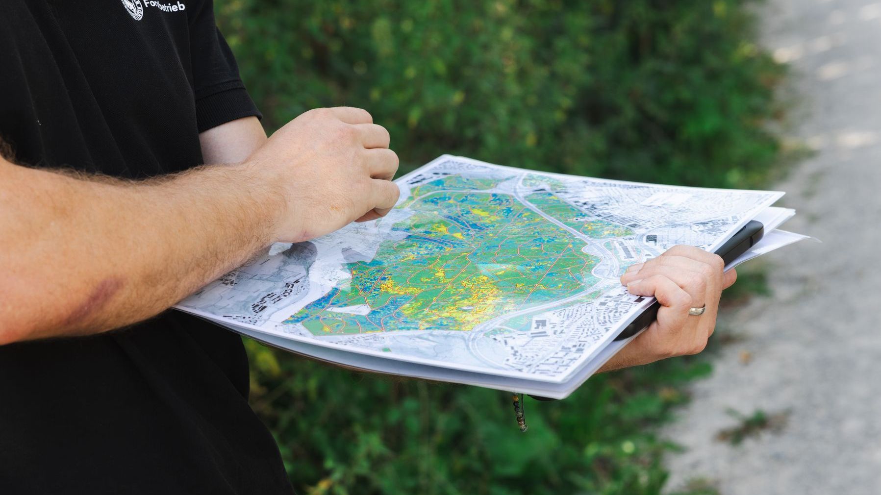 Zwei Händer, welche eine Karte des Waldes halten