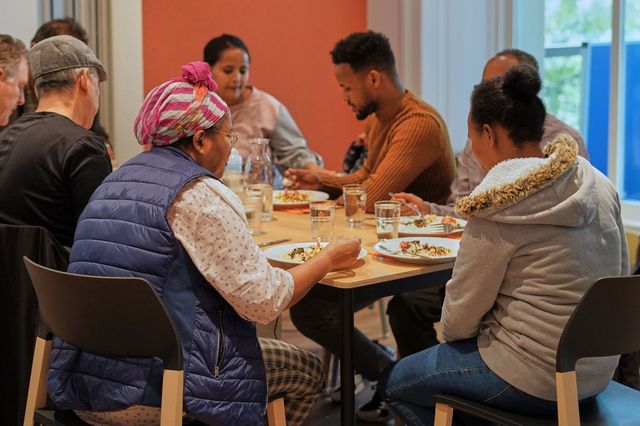 Viele Personen am Tisch von RatPlusTat