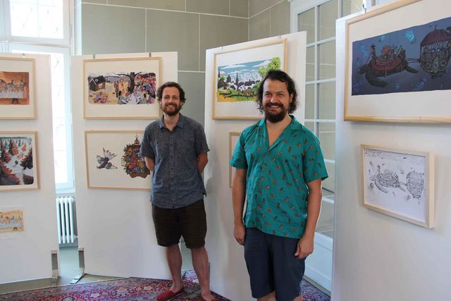 Kunstausstellung mit den zwei Künstlern im Vordergrund