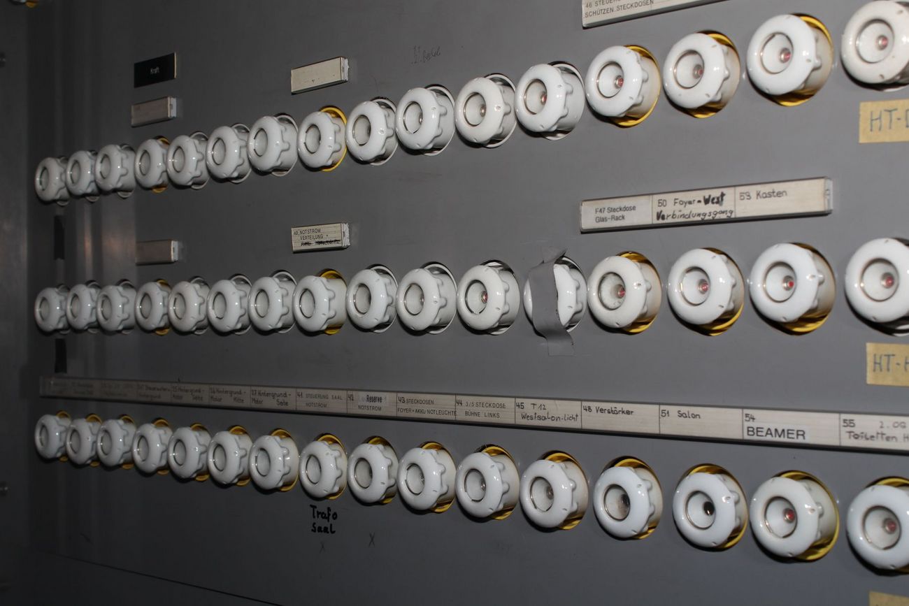 Eine alter Sicherungskasten mit vielen runden Sicherungen in Reihen.