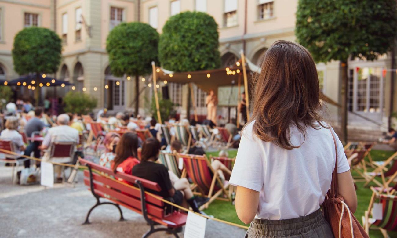 Publikum auf Liegestühlen bei einer Veranstaltung im Innenhof des Berner Generationenhauses.