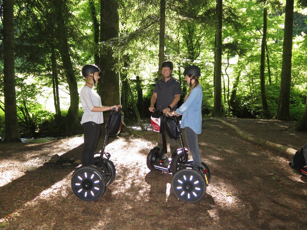 Jugendliche stehen auf den Segways im Wald