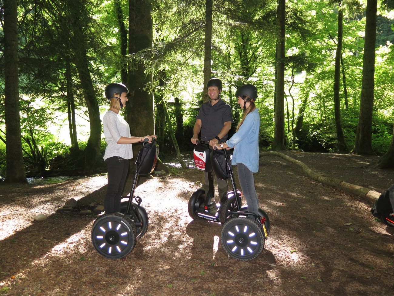 Jugendliche stehen auf den Segways im Wald