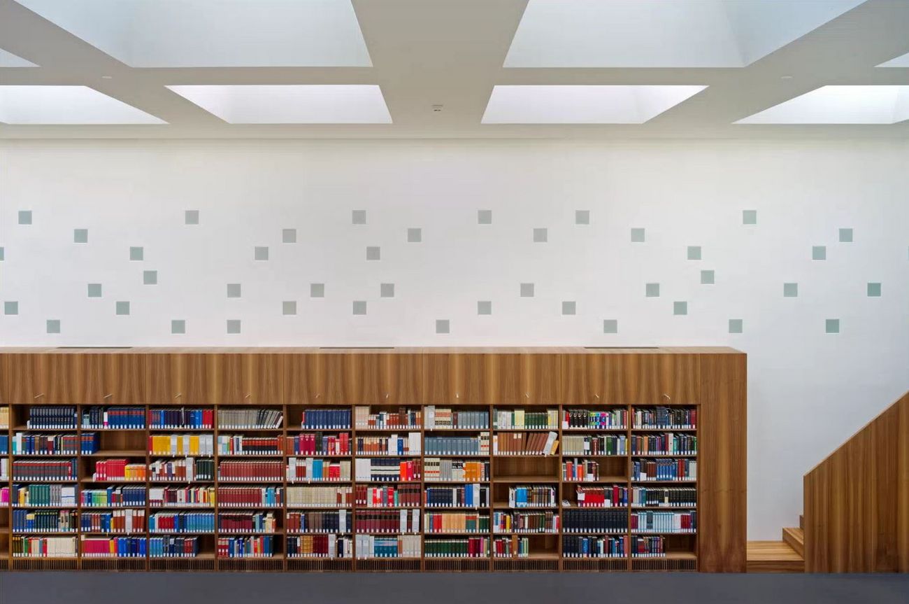 Regal mit vielen Büchern in einem modernen, hellen Raum.