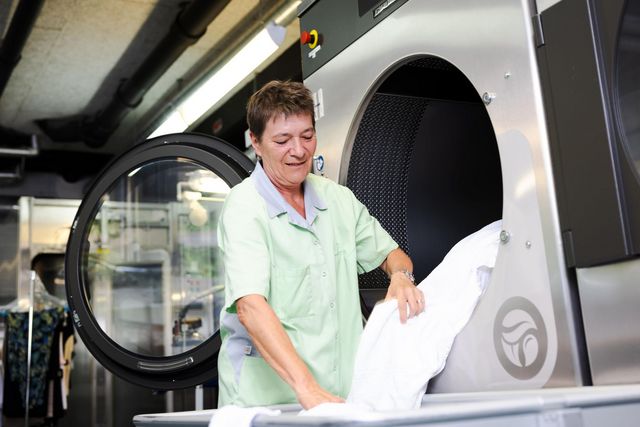 Frau, welche Wäsche aus der Waschmaschine nimmt