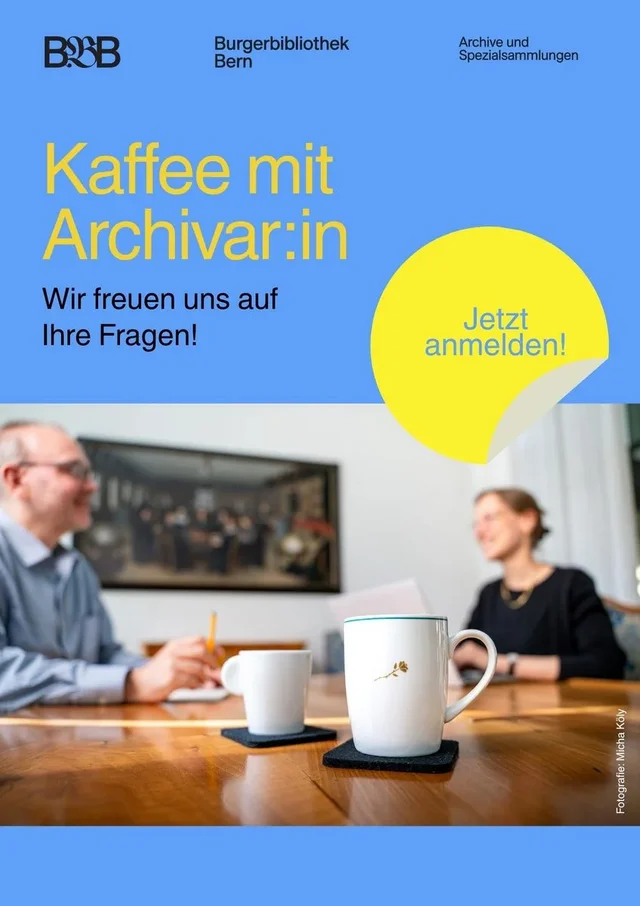Zwei Menschen an einem Tisch mit Tassen im Vordergrund 