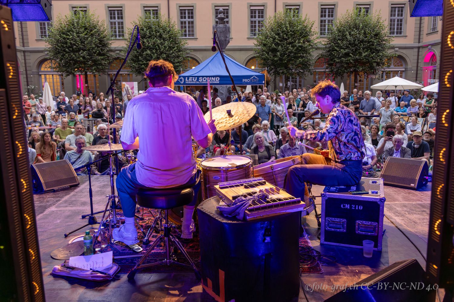 Leute spielen am Schlagzeug vor Publikum