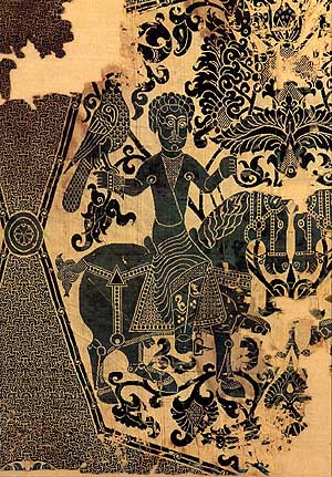 Textilkunstwerk mit einer Reiterfigur, die einen Vogel auf der Hand hält, verziert mit ornamentalen Mustern.